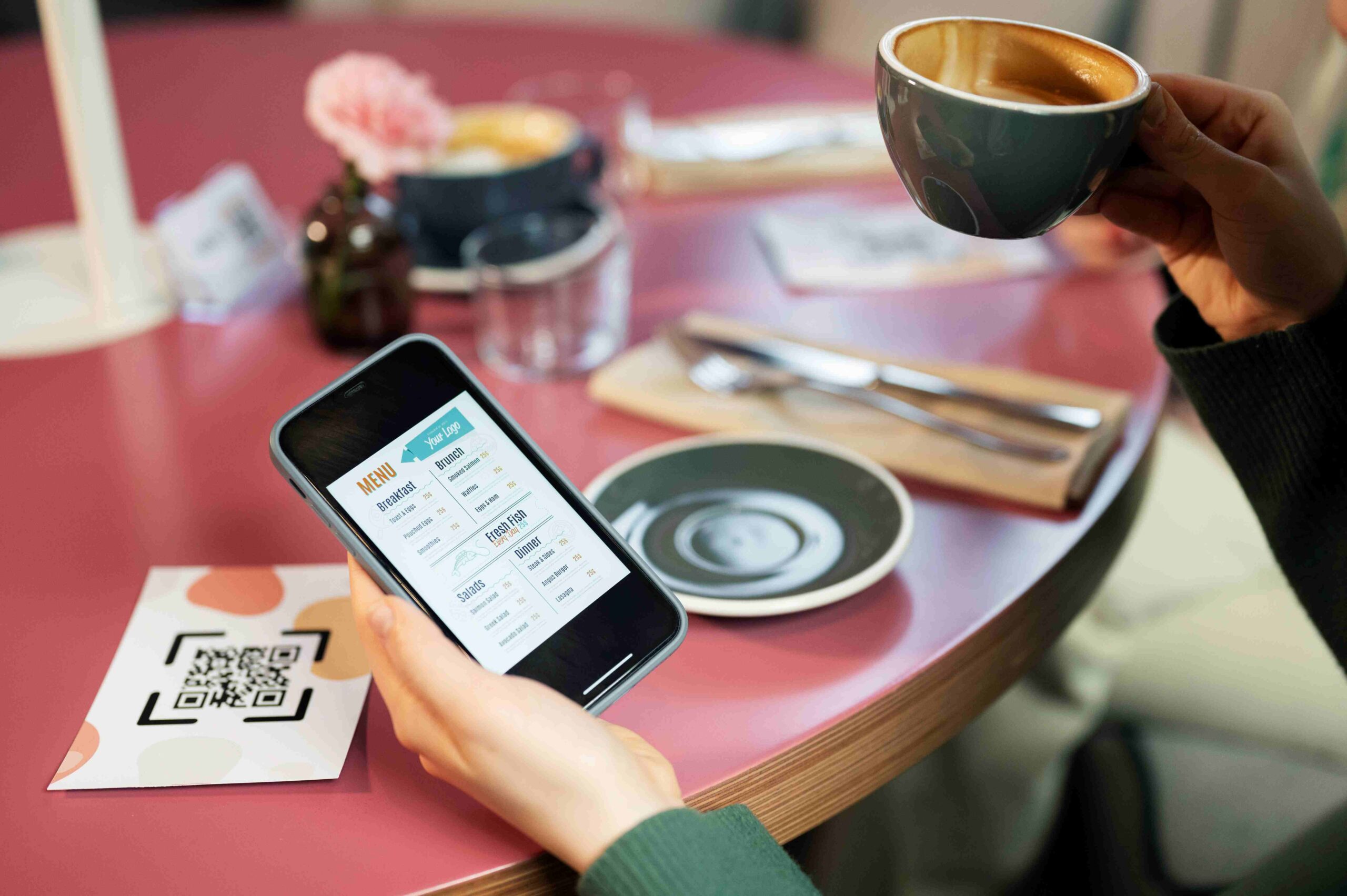 Pessoa escolhendo o que pedir no cardápio digital no celular dentro de uma cafeteria